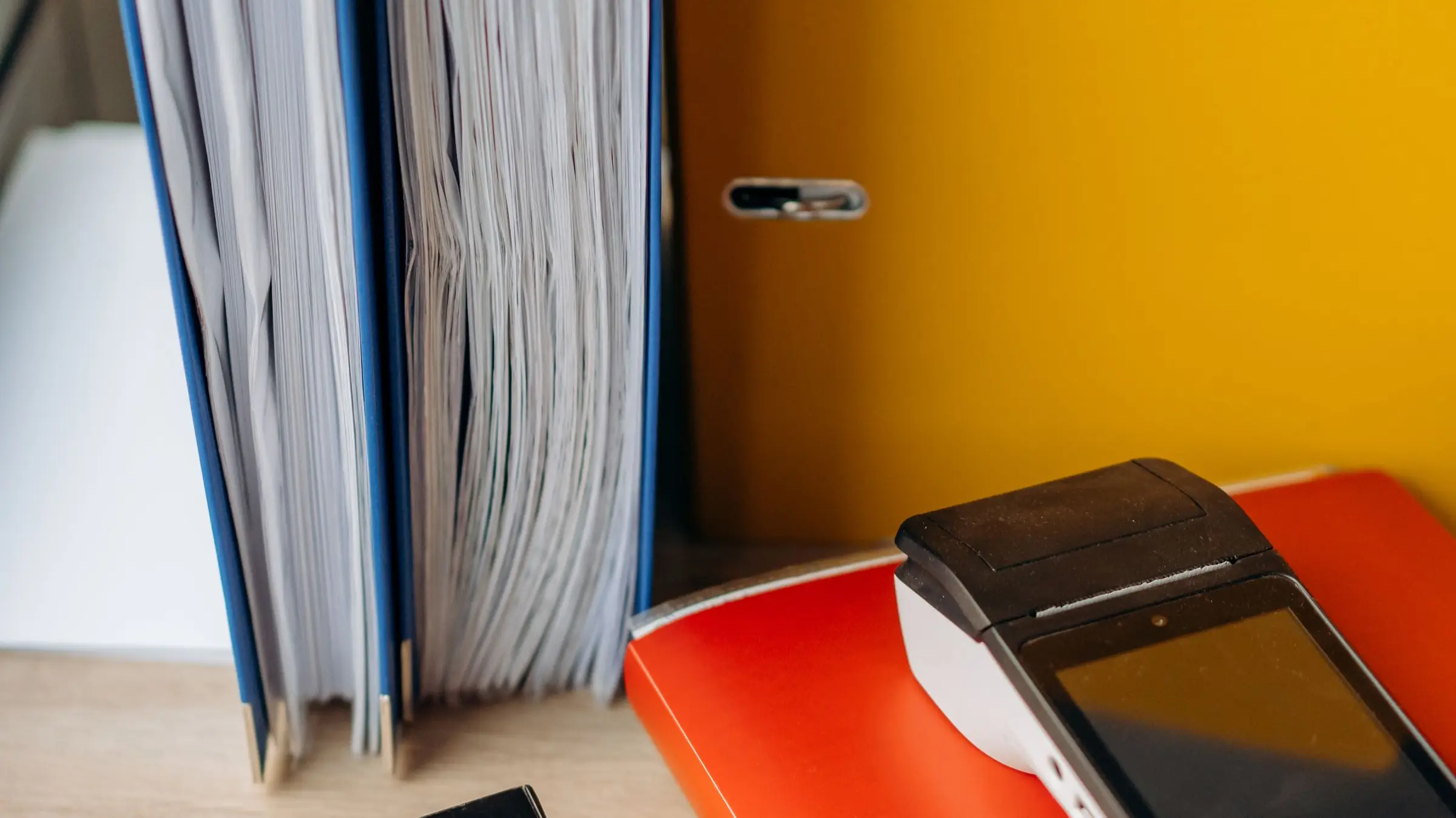 Escritorio de trabajo con libros de contabilidad, una calculadora y facturas ordenadas